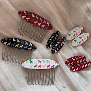 Detail view of colorful Dala horse resin hair combs and spring clips on linen background