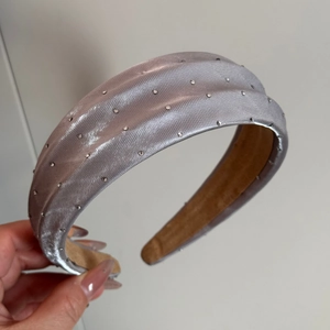 Détail d'un serre-tête en satin lilas avec strass étincelants et design rembourré épais
