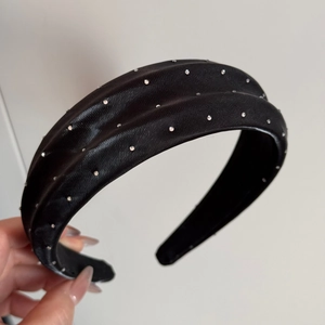 Détail du serre-tête en satin noir avec strass brillants et structure large rembourrée chic