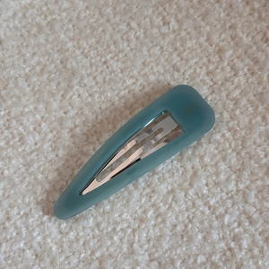 Macro detail of teal acetate teardrop hair clip with France Handmade gold lettering