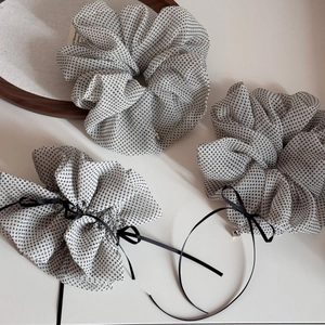 Detail of white polka dot chiffon scrunchies set with ribbons and heart pendants