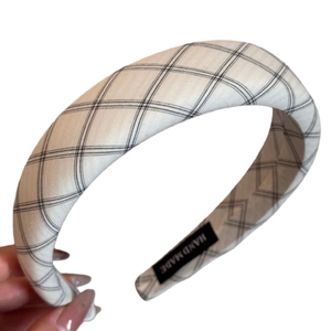 Classic black and white checkered headband with handmade label on white background
