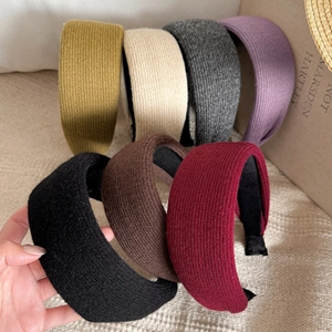 Close-up of wide-brimmed knitted hairbands with ribbed texture in multiple colors