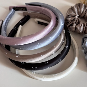 Detail von geblümten Satin-Haarbändern in verschiedenen Farben mit Haargummis