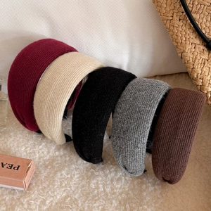 Close-up of thick ribbed knit headbands in classic autumn colors on a soft background