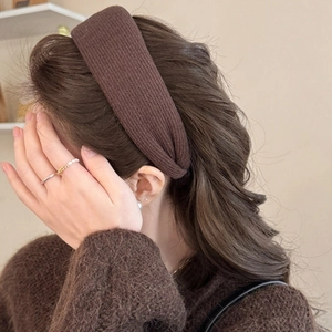 Detail of dark brown ribbed knit headband on model with warm autumn styling