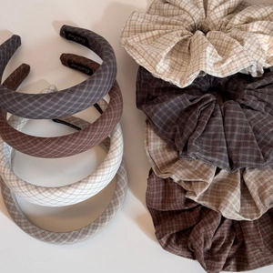 Detail view of vintage plaid scrunchies and headbands in neutral earth tones and soft fabric