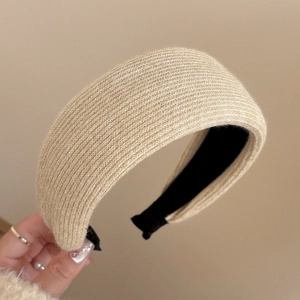 Close-up of beige knitted wide headband showing thick ribbed texture and black non-slip lining