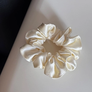 Detailansicht des cremefarbenen Satin-Haarreifs mit Blumenmuster und feiner Stofftextur