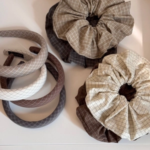 Close-up of vintage plaid fabric scrunchies and headband in earth tones for hair styling