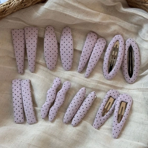 Set of 14 purple polka dot fabric hair clips in various geometric shapes on beige fabric