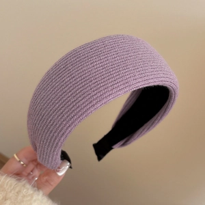 Macro shot of purple knitted headband showing detailed ribbed texture and black inner lining