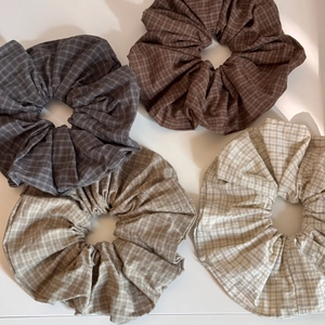 Flat lay of four vintage plaid fabric scrunchies in earthy brown and grey tones