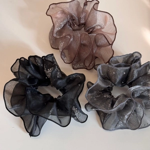 Detailed view of three organza scrunchies with glitter rhinestones and wavy edges