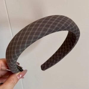 Detail shot of vintage grey plaid fabric headband with elegant white checkered pattern texture