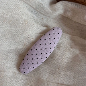 Detail of purple polka dot fabric hair clip showing natural linen texture and pattern