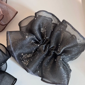 Detailed texture of sheer organza hair scrunchies with silver glitter in various colors