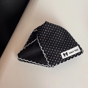 Close-up of black and white polka dot lace hair claw with elegant fabric texture detail
