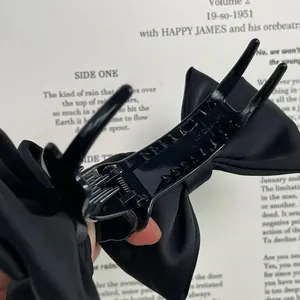 Élégante grande pince à cheveux à double nœud en satin noir pour queue de cheval de femme