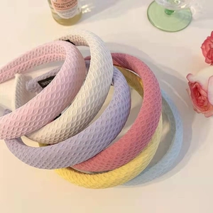 Détail de serre-têtes en éponge gaufre colorés avec étiquettes faites à la main