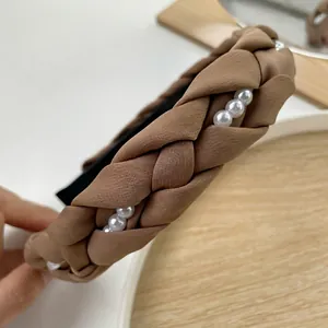 Vue rapprochée du serre-tête tressé beige avec perles et texture épaisse en maille tricotée