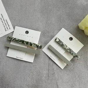 Elegant green marble and matte duckbill hair clips set on a stylish gray background