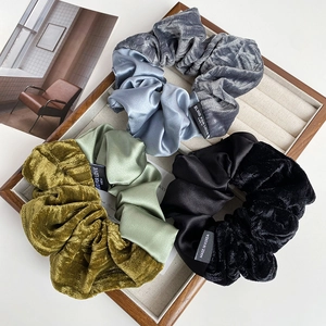 Detail of velvet and satin scrunchies set with Blind for Love woven label in wooden tray