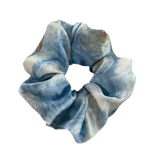Elegant large scrunchie with blue and white ink marble pattern in glossy satin fabric