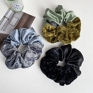 Detail view of velvet and satin hair scrunchies with text label on a white background
