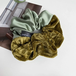Detail of velvet and satin scrunchie with Blind For Love text label on magazine
