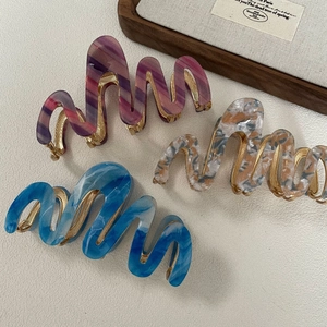 Drie golfvormige haarklemmen van acetaat met marmerpatroon en stevig metalen frame