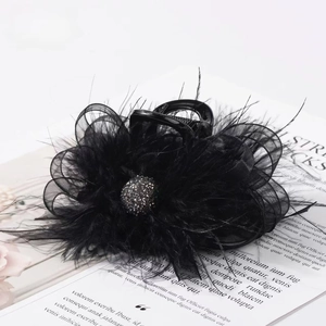 Elegant black hair claw clip featuring ostrich feathers and mesh ribbon on a magazine