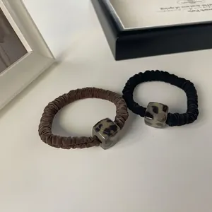 Two-pack elastic scrunchies with coffee and black leopard print resin squares