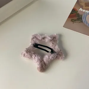 Detalle de la pinza de estrella de felpa con mohair sintético en tono gris púrpura
