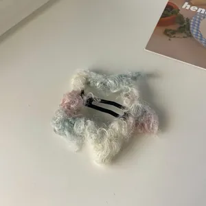Detalle de pinza para el pelo con estrella de felpa degradada rosa y azul y clip metálico BB
