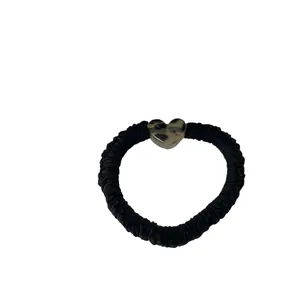 Elastic black scrunchie with leopard print heart resin charm on white background