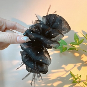Elegant black mesh hair claw with silver rhinestones and feathers for a voluminous look