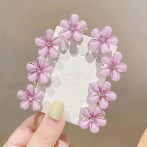 Détail de mini pinces à cheveux fleurs violettes avec strass sur carte de vente