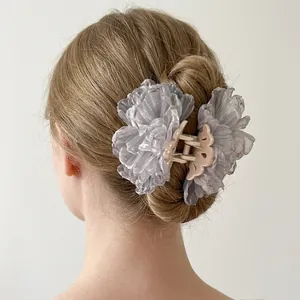 Elegant grey organza flower hair claw clip with pearl details on a model's head