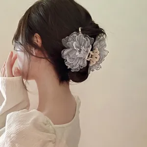 Elegant grey organza flower hair claw clip shown in a stylish updo hairstyle