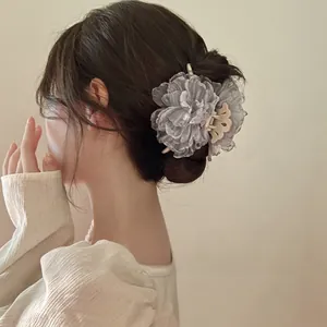 Detailed view of an elegant large grey organza flower hair claw clip worn by a model