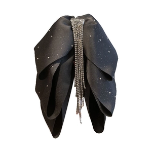 Detail of black bow hair clip with sparkling rhinestones and elegant hanging tassels