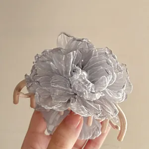 Close-up of the delicate mesh petals and pearl center of this floral hair claw clip