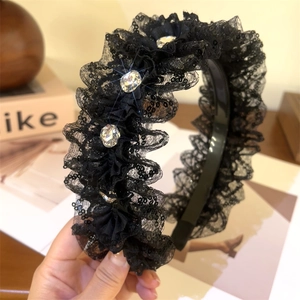 Elegant black lace headband with rhinestones and sequins for a high cranial top hairstyle