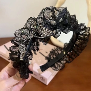 Französisches Spitzen-Haarband mit Pailletten und Strass-Schmetterling auf einem Holztisch