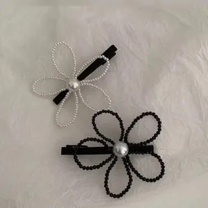 Elegant floral hair clips with pearl centers in black and white minimalist colors