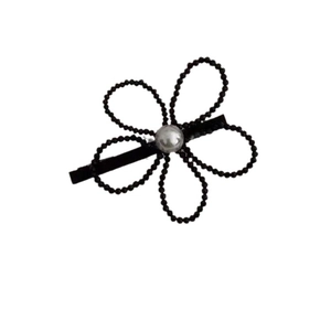 Elegant floral hair clip with black beaded petals and a central pearl on a white background