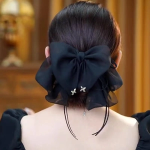 Détail d'une grande pince à cheveux nœud en mousseline noire avec pendentif papillon