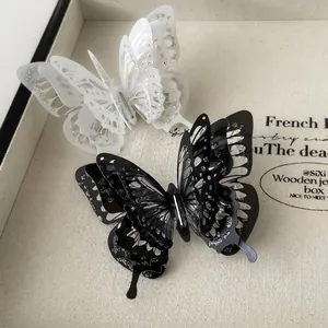 Exquisite 3D layered butterfly hair clips in black and white with silver glitter edges