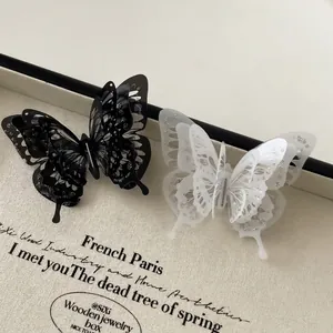 Elegant 3D butterfly hair clips in black and white with silver glitter on wings